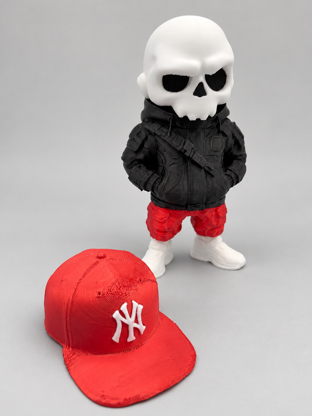 Front view of Bronx Bones skull figure with its removable red New York Yankees cap displayed separately