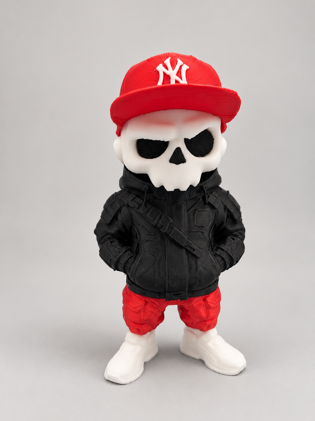 Skull figure wearing a removable red New York Yankees cap, black jacket, red pants and white boots