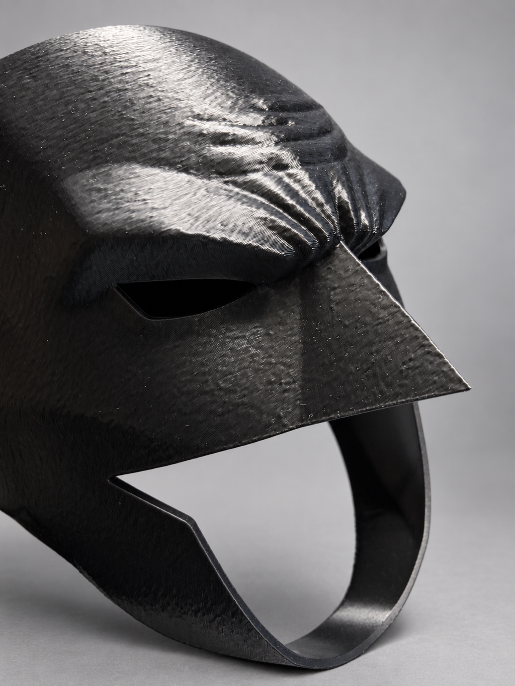Close-up of black 3D-printed cowl mask with sculpted brow and open lower face